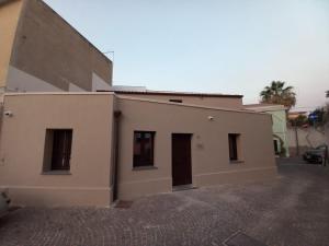 a white building with two doors on the side of it at La casetta Guest House Oristano in Oristano