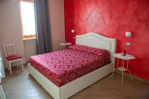 um quarto com uma cama branca e uma parede vermelha em I Milord 2 em Castel San Giorgio