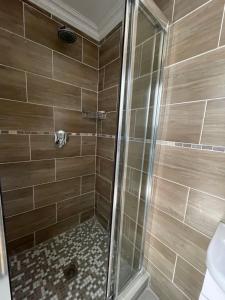 een douche met een glazen deur in de badkamer bij Spacious stay-in bachelor apartment in Kempton Park