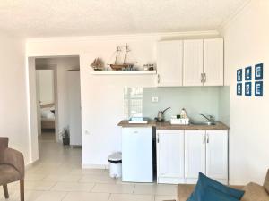 una cucina con armadi bianchi e una barca sul muro di ORA apartments a Donji Štoj