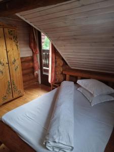 Cette chambre comprend un grand lit et un plafond en bois. dans l'établissement Cabana Haiducului, à Soveja