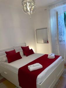 a white bedroom with a large bed with red pillows at Podesti 6 in Rome