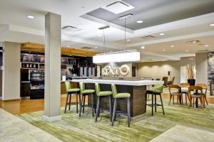 a lobby with a bar with green bar stools at Courtyard Houston I-10 West/Energy Corridor in Houston