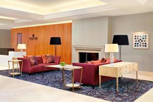 a living room with red furniture and a fireplace at Sheraton Skyline Hotel London Heathrow in Hillingdon