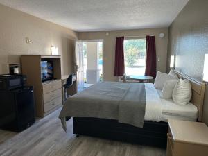 a bedroom with a large bed and a television at Travelers Rest Motel in Bogalusa