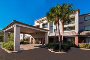 サラソタにあるCourtyard Sarasota Bradenton Airportのヤシの木が目の前にあるホテル