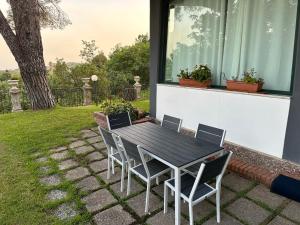 uma mesa preta e cadeiras num pátio em Villa Roccia Scura dell'Etna em Zafferana Etnea