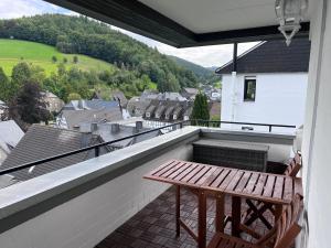 einen Balkon mit einer Holzbank und einem Tisch in der Unterkunft Vakantiewoning Paula Sauerland in Schmallenberg
