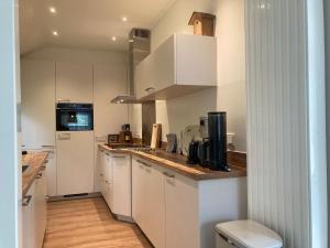 une cuisine avec des placards blancs et un comptoir dans l'établissement Cozy Holiday home in Koudekerke Zealand, à Dishoek