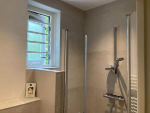 La salle de bains est pourvue d'une douche et d'une fenêtre. dans l'établissement Cozy Holiday home in Koudekerke Zealand, à Dishoek