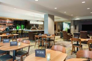 a restaurant with tables and chairs and a bar at Courtyard Sarasota Bradenton Airport in Sarasota