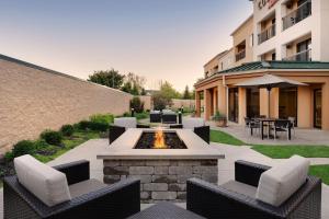 a patio with a fire pit and chairs and a building at Courtyard by Marriott Indianapolis South in Indianapolis
