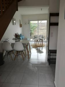 a living room with a dining room table and chairs at Appartement 4 personnes à louer in Ouistreham
