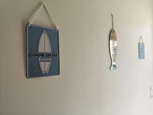 a sign for a surfboard hanging on a wall at Appartement 4 personnes à louer in Ouistreham
