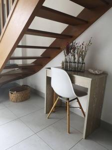 une chaise blanche assise à côté d'un bureau en bois dans l'établissement Appartement 4 personnes à louer, à Ouistreham