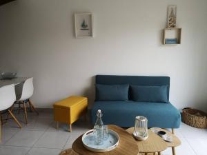 un salon avec un canapé bleu et une table dans l'établissement Appartement 4 personnes à louer, à Ouistreham