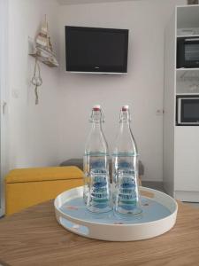 three bottles sitting on a tray on a table at Appartement 4 personnes à louer in Ouistreham