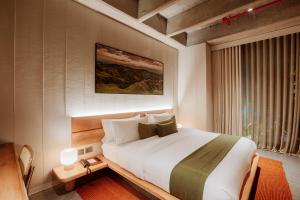 um quarto com uma cama grande e uma janela em Hotel El Zarzo em Medellín