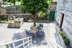 eine Terrasse mit einem Tisch, Stühlen und einem Baum in der Unterkunft Casa Donas in Gondomar