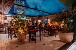 a restaurant with tables and chairs and people in the background at Hotel El Zarzo in Medellín