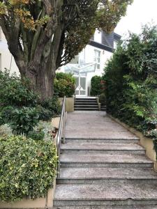 een trap naar een huis met een boom bij Privates Apartment mit Bad, Küche, Sofa & Balkon in Frankfurt am Main