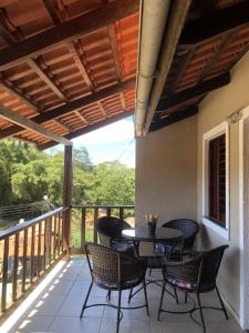 a patio with a table and chairs on a balcony at TRIPLEX SOLAR CASA BRANCA in Guaramiranga