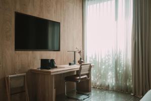 a hotel room with a desk with a television and a window at Hotel El Zarzo in Medellín