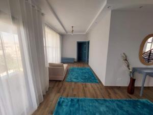 ein Wohnzimmer mit einem Sofa und blauen Teppichen in der Unterkunft Villa Bakr in Alexandria
