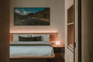 a bedroom with a bed and a painting on the wall at Hotel El Zarzo in Medellín