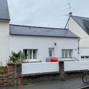 ein weißes Haus mit einem weißen Zaun davor in der Unterkunft A home away from home in Rennes