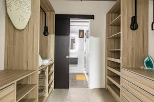 a bathroom with wooden cabinets and a walk in closet at Acogedor, Moderno y Vanguardista, Apartamento de dos Habitaciones en Cayalá, Encanto Cayala in Guatemala