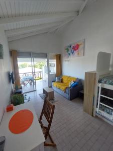 una sala de estar con un sofá y una mesa en Studio Ti Coco, en Sainte-Anne