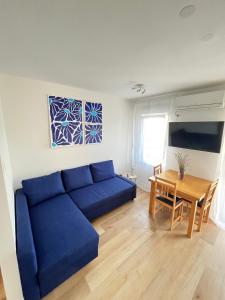 a living room with a blue couch and a table at Apartment TIM in Split