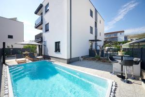 a swimming pool in front of a building at ZEN apartment - private pool in Trogir