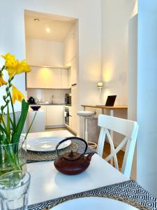 une table avec un vase de fleurs jaunes et une cuisine dans l'établissement European Comission Beautiful Studio, à Bruxelles