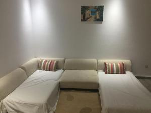 sala de estar con sofá y 2 almohadas en Résidence le corail de chat meriem en Sousse