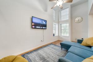 uma sala de estar com um sofá azul e uma televisão de ecrã plano em Fast Wifi, 7 Miles to DFW em Euless