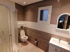 La salle de bains est pourvue de toilettes, d'un lavabo et d'une fenêtre. dans l'établissement Résidence le corail de chat meriem, à Sousse
