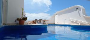 een zwembad naast een wit gebouw met een glijbaan bij Hotel & Museo Casa Turquesa in Cancun