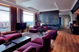 a living room with purple couches and a television at Copenhagen Marriott Hotel in Copenhagen