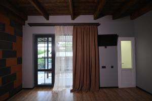 um quarto vazio com uma janela e uma porta em Guest House em Guiumri