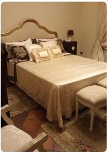 een slaapkamer met een groot bed met kussens en een stoel bij Guesthouse DaVinci in Lamporecchio