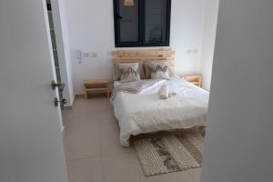 a bedroom with a bed with a teddy bear on it at A modern apartment in Acre in ‘Akko