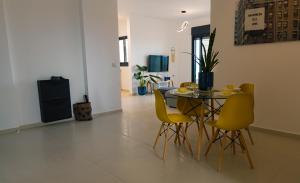 a dining room with a table and yellow chairs at A modern apartment in Acre in ‘Akko