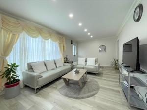 a living room with a couch and a tv at Luxurious Cozy House in Bluffs with Lake View in Toronto