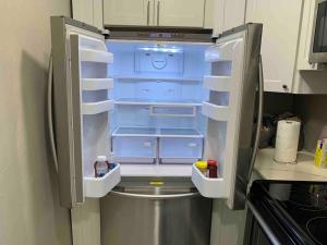 an empty refrigerator with its door open in a kitchen at Apartment in Daytona Beach 1BR 1Bath Centrally Located in Daytona Beach