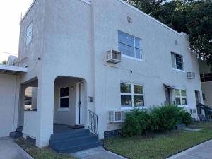 a white brick house with a door and stairs at Apartment in Daytona Beach 1BR 1Bath Centrally Located in Daytona Beach