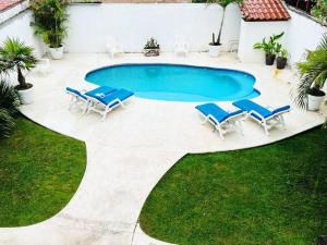 une piscine avec des chaises longues et une piscine dans l'établissement Casa San Marcos, à Lo de Marcos