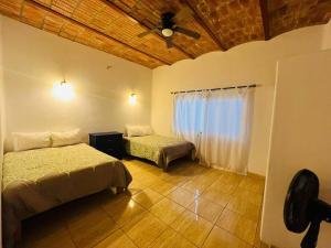 - une chambre avec 2 lits et un ventilateur de plafond dans l'établissement Casa San Marcos, à Lo de Marcos