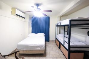 a room with two bunk beds and a ceiling fan at Sohla Rooftop Hostel in San Juan del Sur